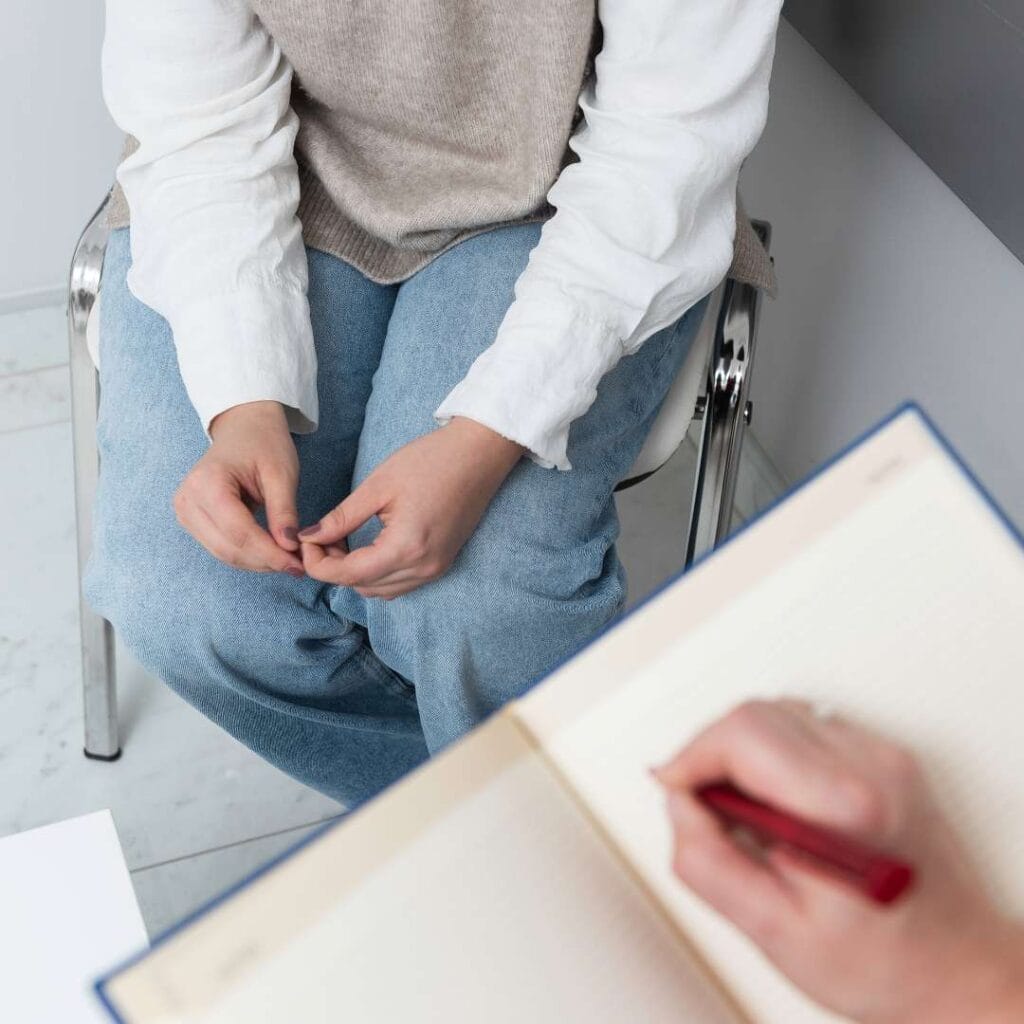 Woman sitting alone looking distressed, representing loss of control around food and binge eating disorder symptoms
